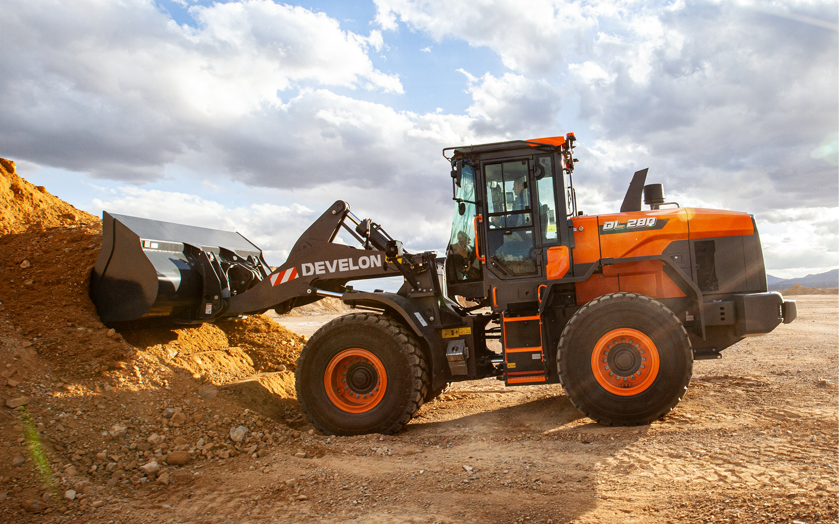 Wheel loader scooping dirt from a job site