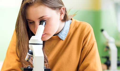Girl looking into a microscope
