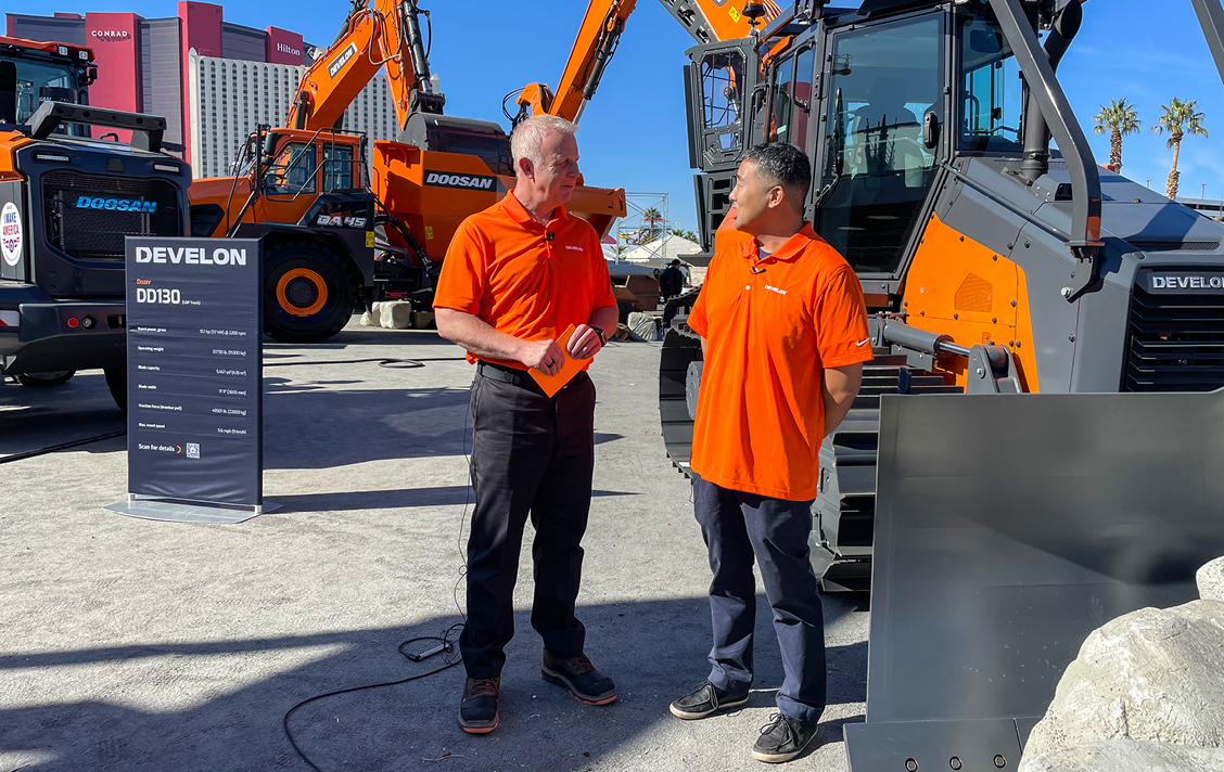 Photo of Scott Hoke of MotorTrendTV interviewing Moo Young Park, Engineering Manager, about the new DEVELON dozer at the DEVELON booth at CONEXPO.