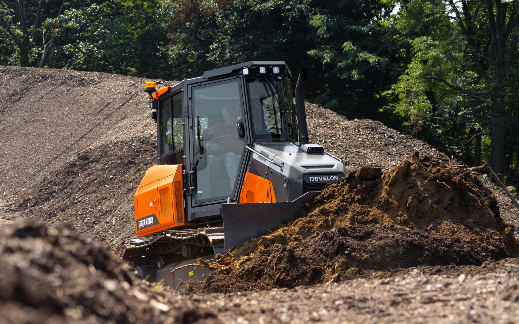 A DEVELON DD100 dozer grading on a job site.