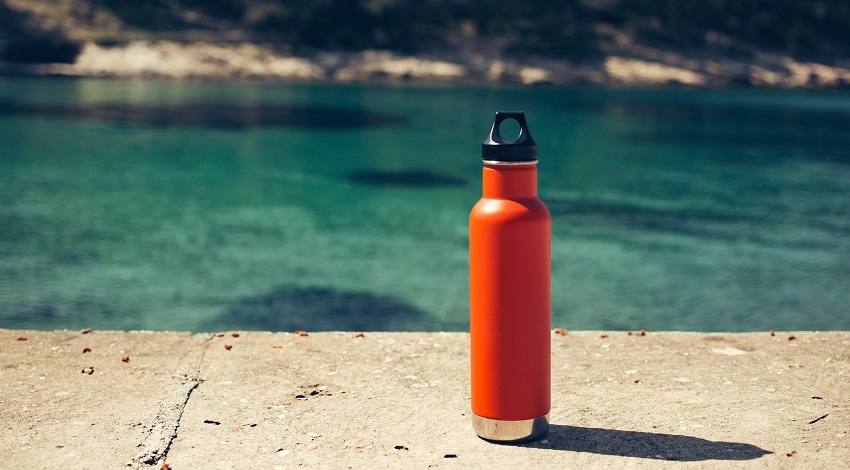 An orange reusable metal waterbottle