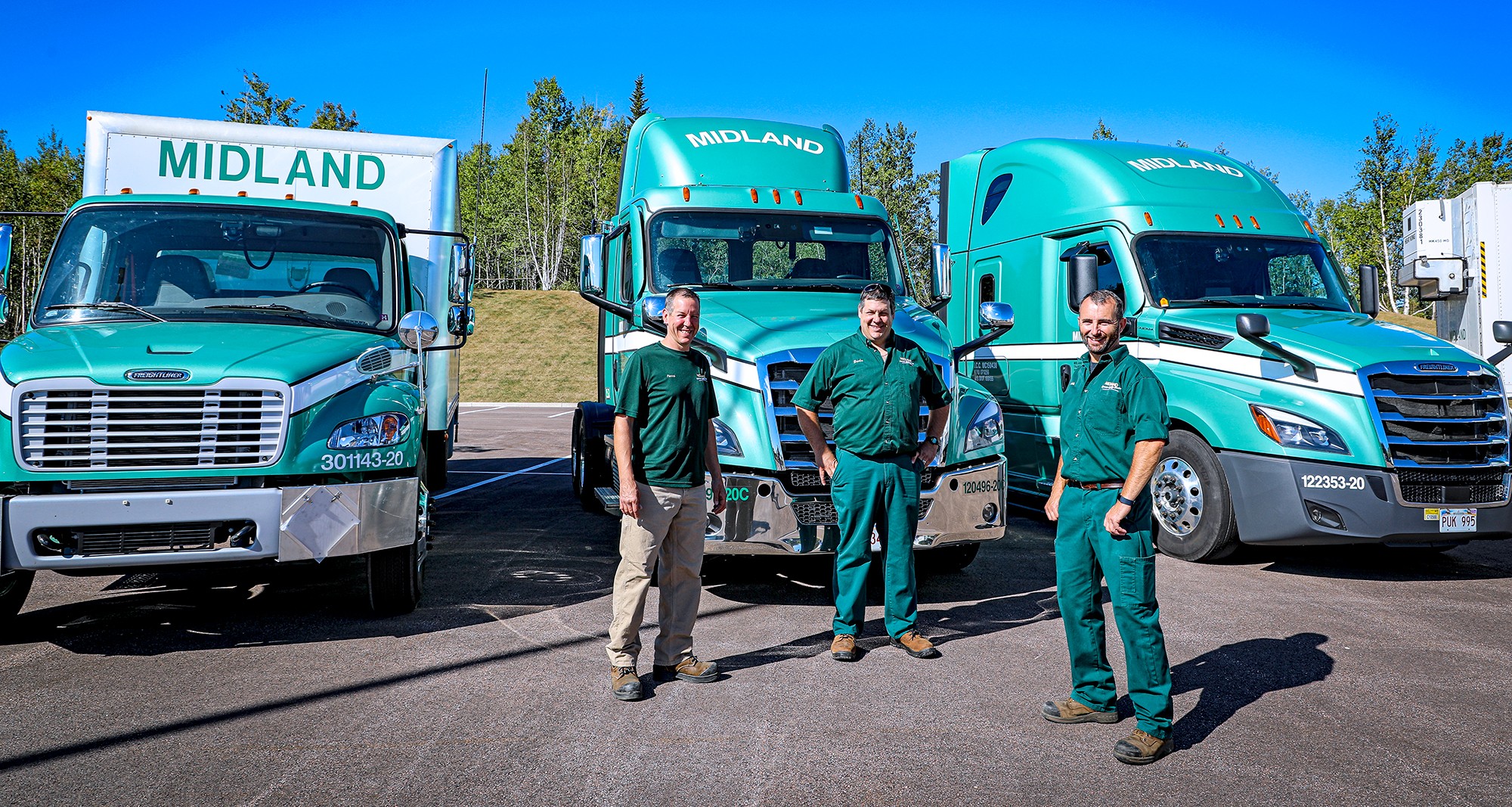 Three Midland drivers posing in front of their trucks