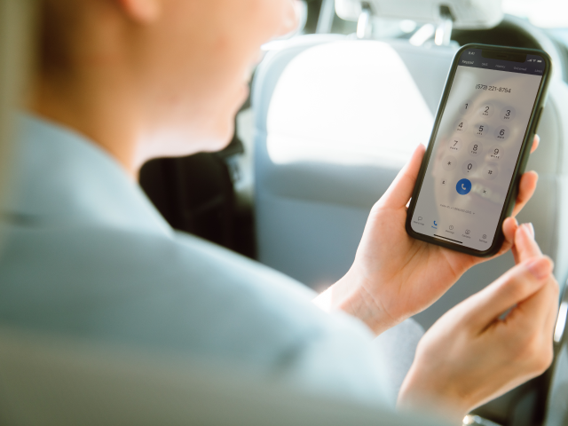 person holding phone in backseat