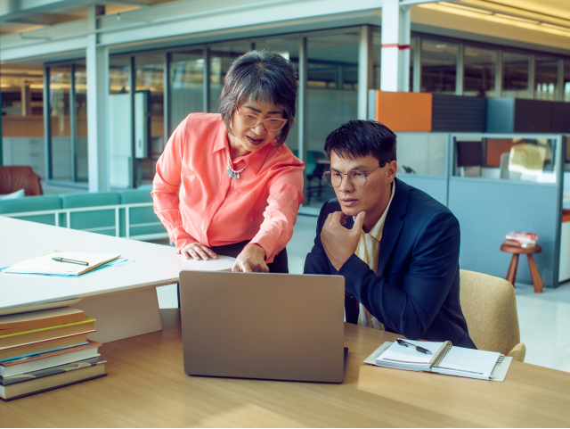 Hybrid Work Office Two people looking at laptop