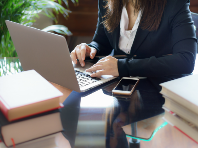 Vrouw die achter een laptop werkt